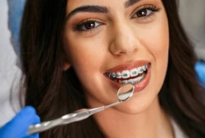 smiling woman with braces undergoing dental check up